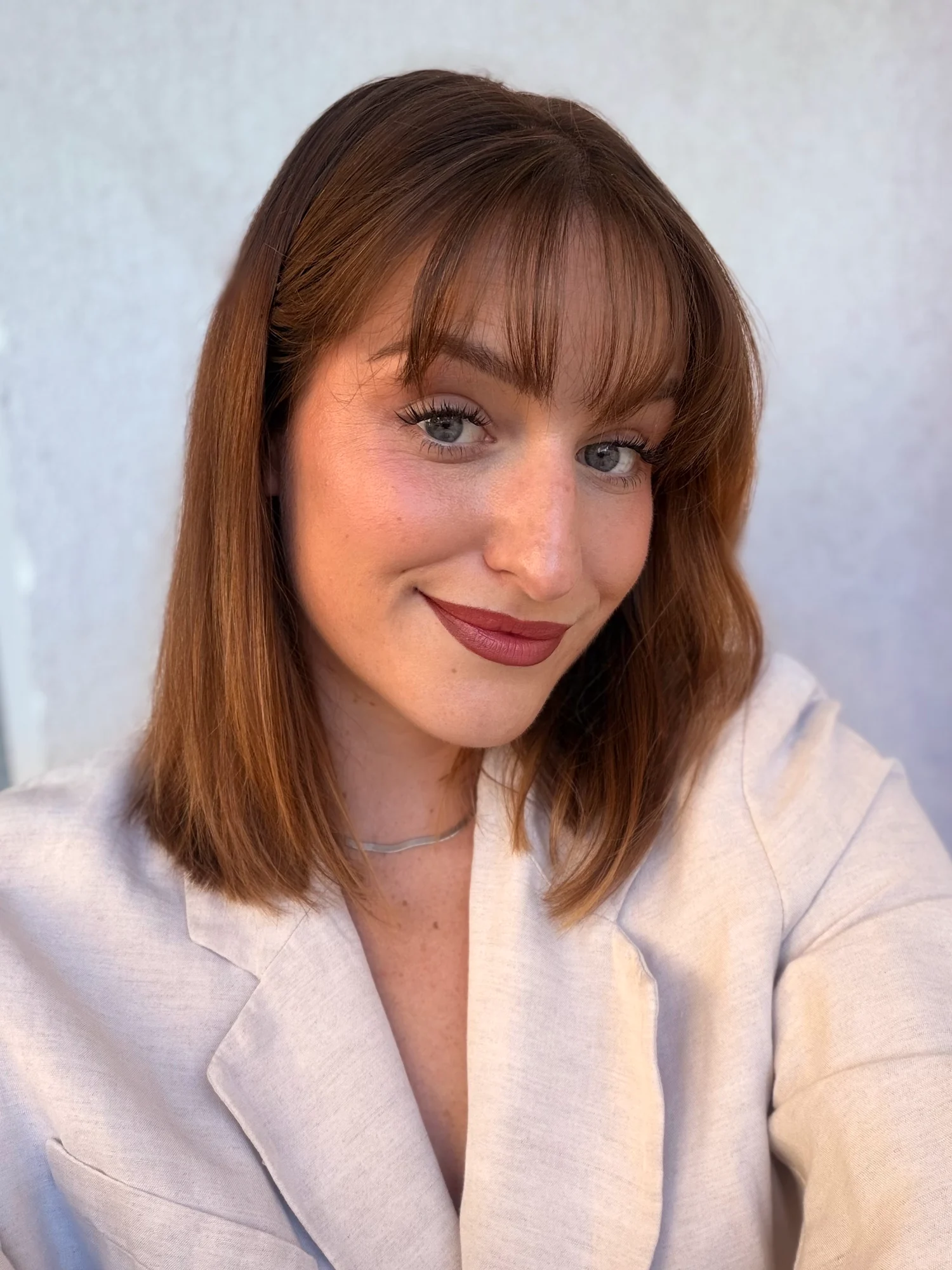 Portrait de Faustine Guéranger : carré auburn à frange, regard bleu souligné et lèvres bois de rose